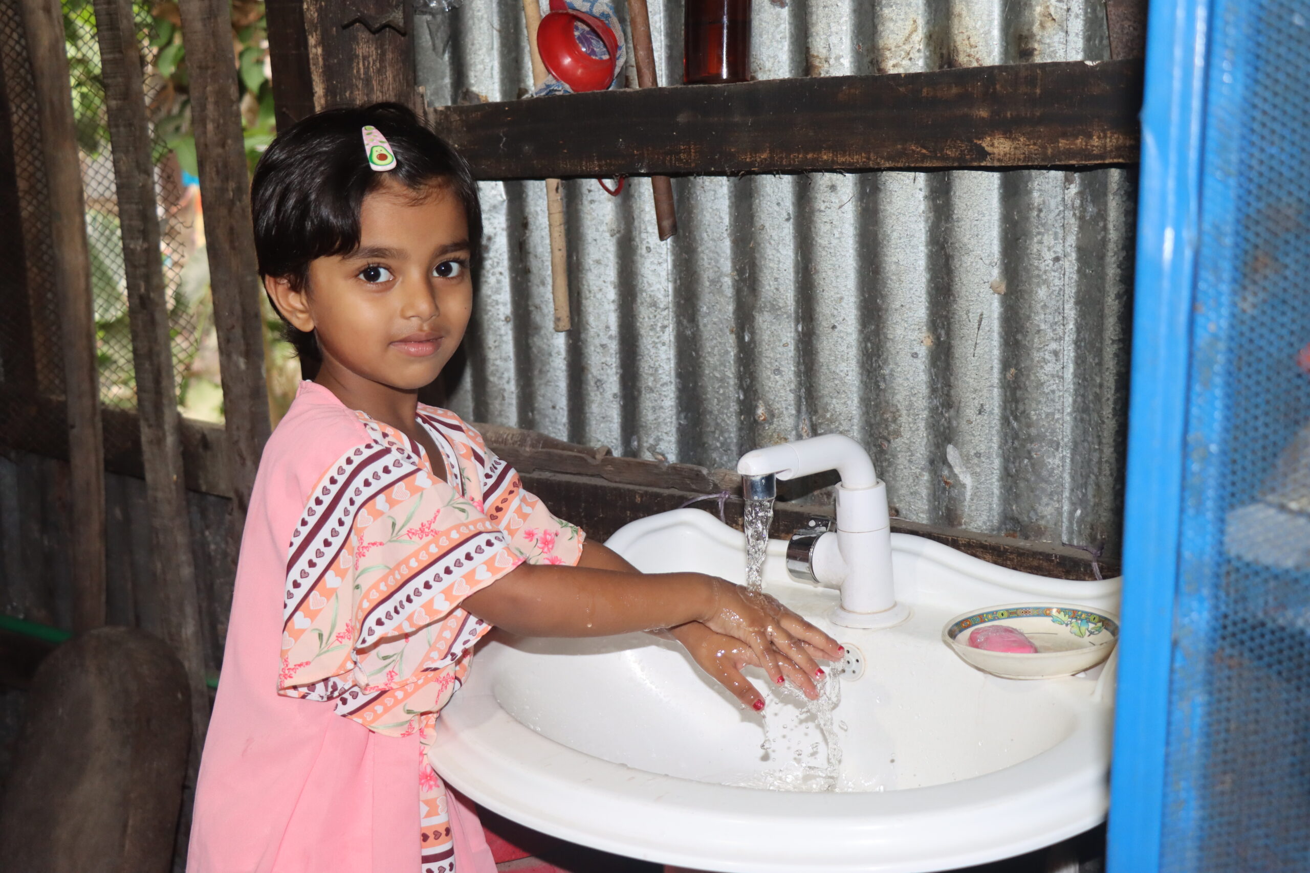 Maisha washing her hands Maisha is washing her hand with running water from a Max TapWater grid.